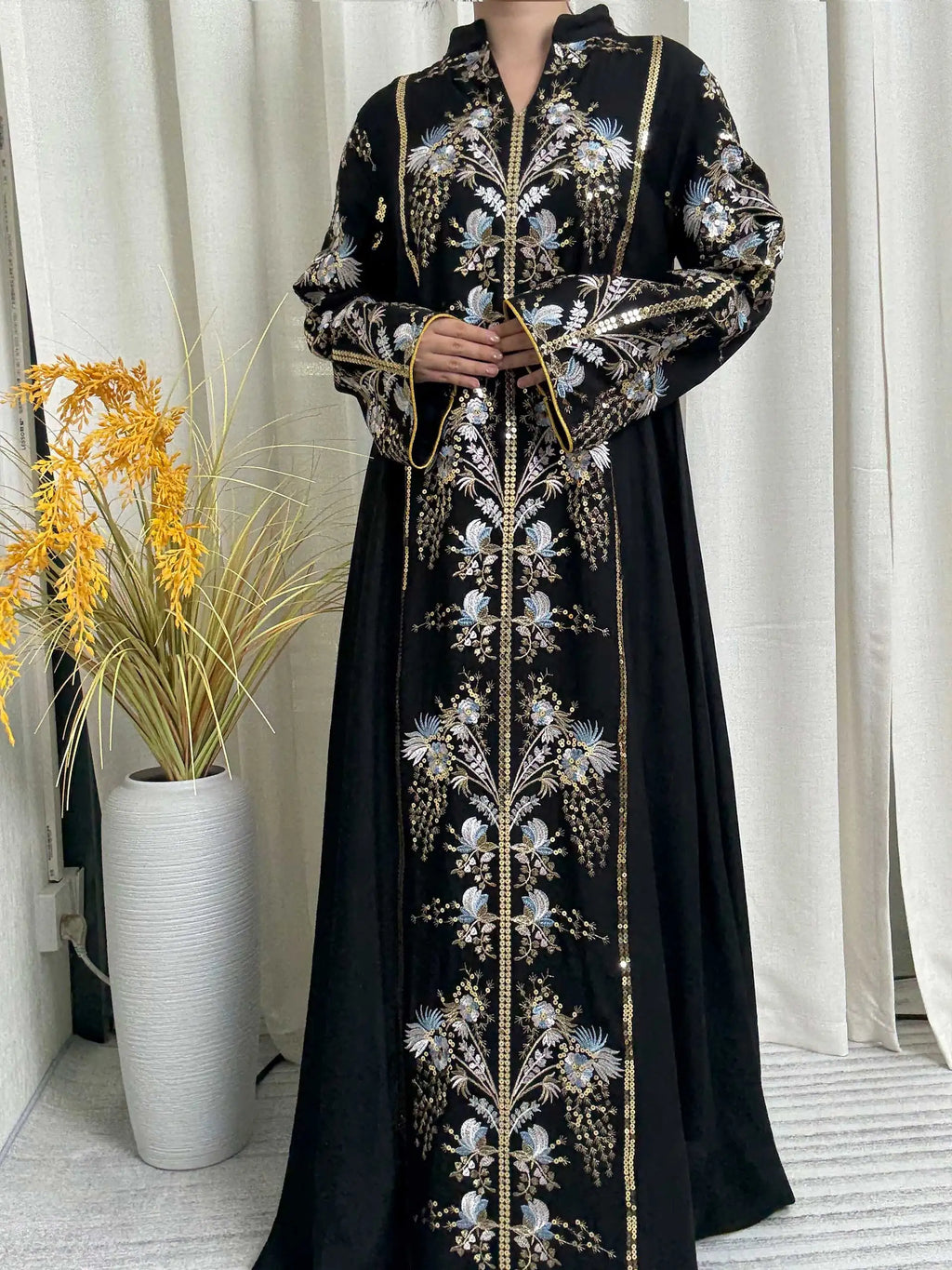 فستان أسود يجمع بين الأناقة والحداثة مع رقبة تصميم فريدة وتطريزات مبهرة تضفي لمسة ساحرة.