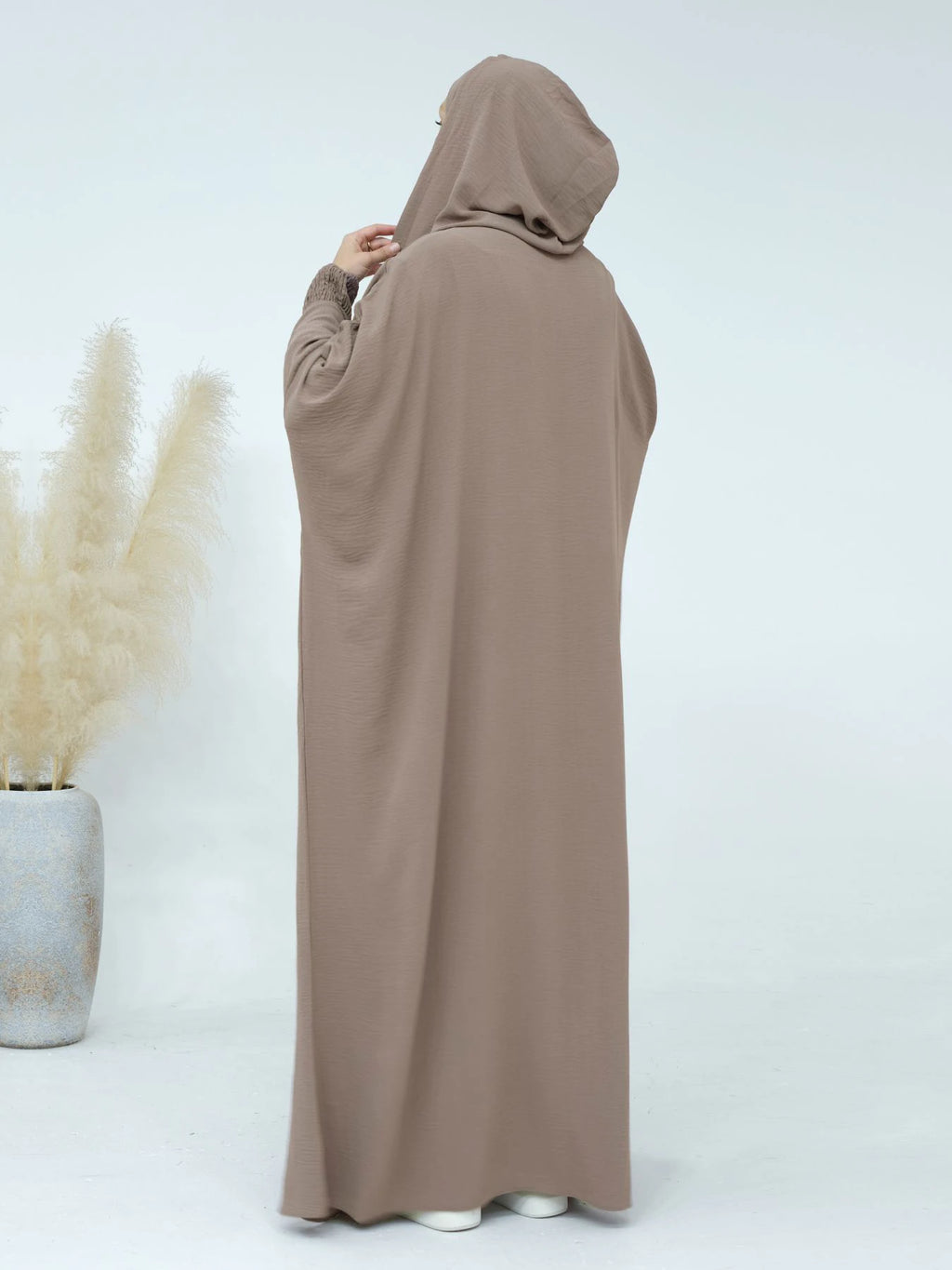 عباءة النسائية المزينة بتعليقات تضفي لمسة من الأناقة المرحة.