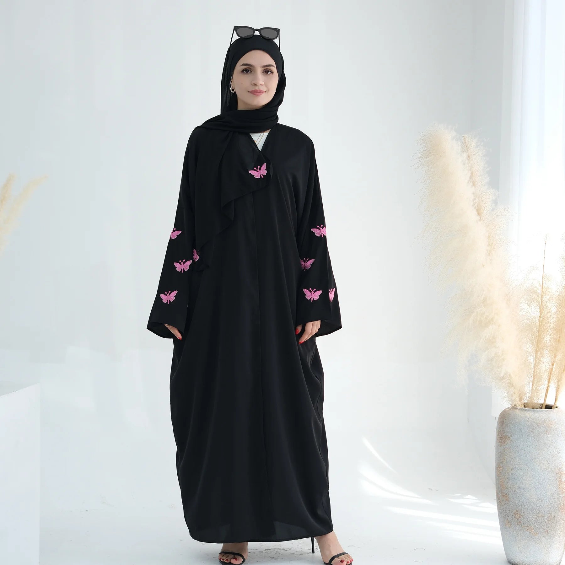 تجسد هذه العباءة المفتوحة تطريز الفراشة الدقيق بتصميم الكيمونو،