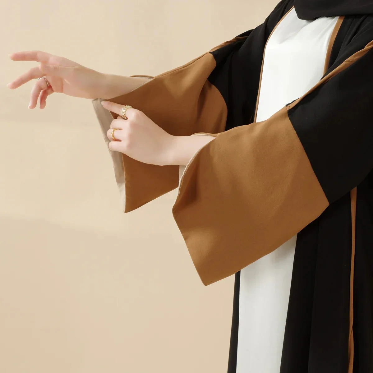 عباءة أنيقة تجمع بين الأسود والبني بتصميم يناسب كل مناسبة، من الارتداء اليومي إلى الاحتفالات الخاصة.