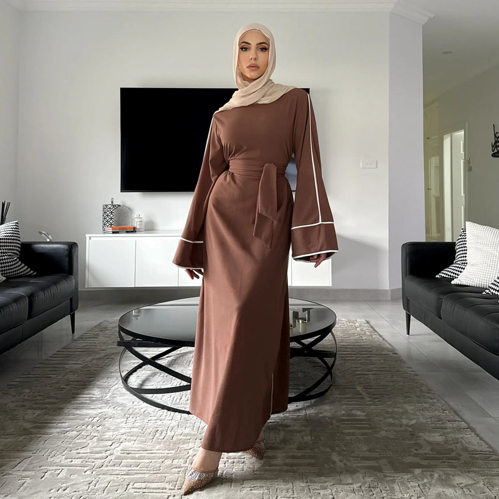 عباءة بيج جديدة لعام 2025 تجمع بين الراحة والأناقة مع حزام عند الخصر يبرز جمال قوامك. تصميم الأكمام مناسب للاستخدام اليومي،
