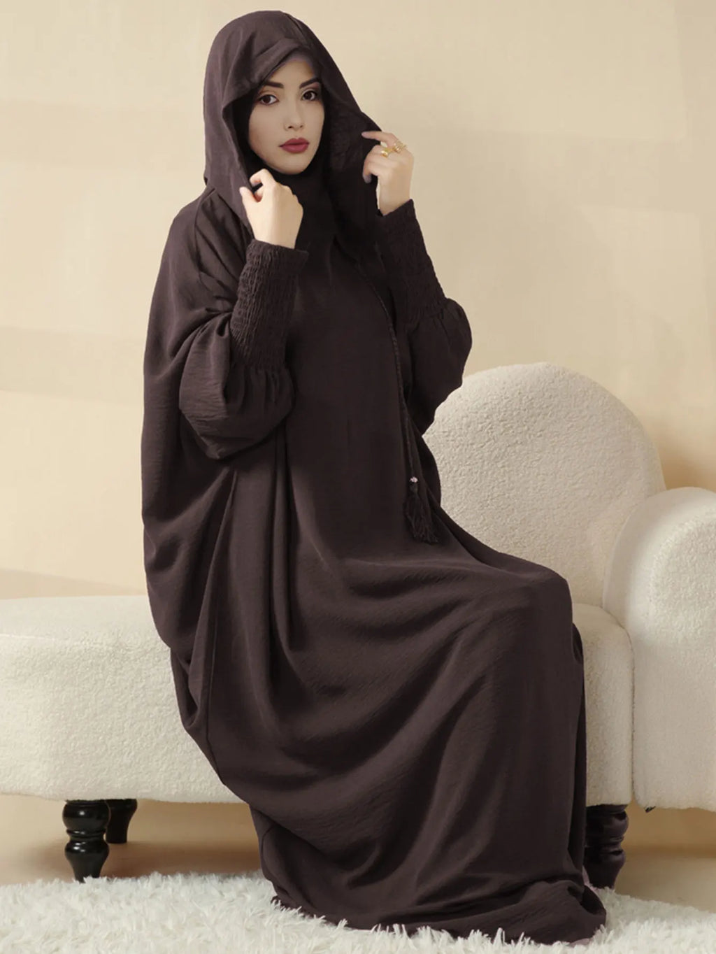 عباءة النسائية المزينة بتعليقات تضفي لمسة من الأناقة المرحة.