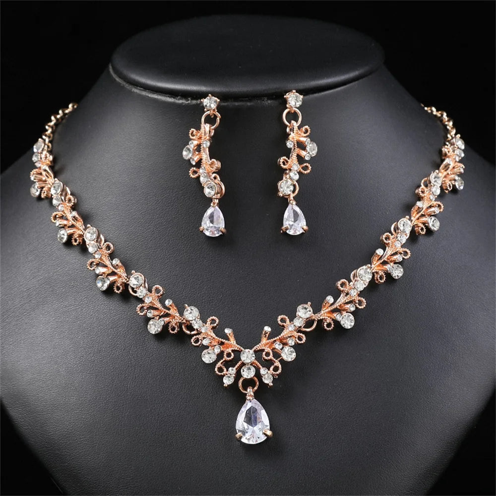 طقم مجوهرات أنيق يتضمن أقراط متدلية وعقد مزين بحجر الراين يضفي إشراقة مميزة.